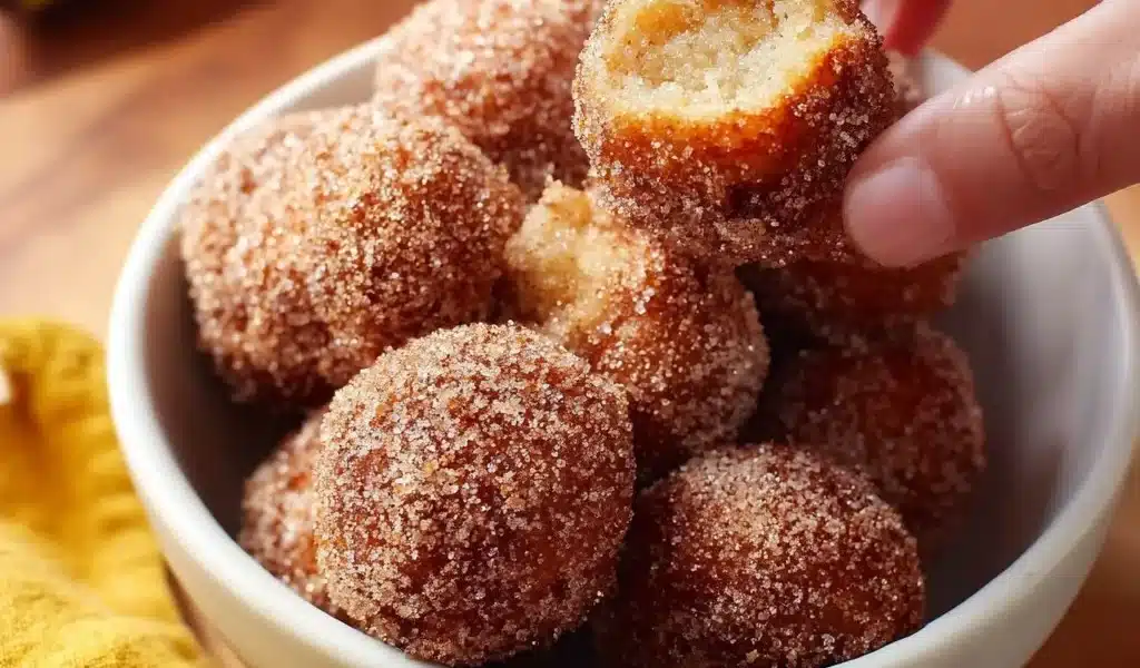 2-Ingredient Banana Donut Holes 8 2-ingredient banana donut holes on a plate with powdered sugar.