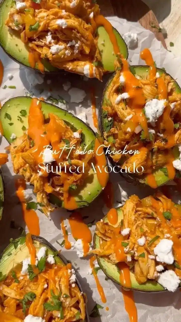 Buffalo Chicken Stuffed Avocados plated with fresh garnishes