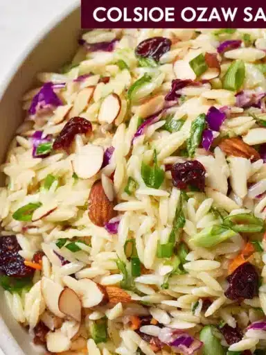 Bowl of coleslaw orzo salad with fresh vegetables and dressing